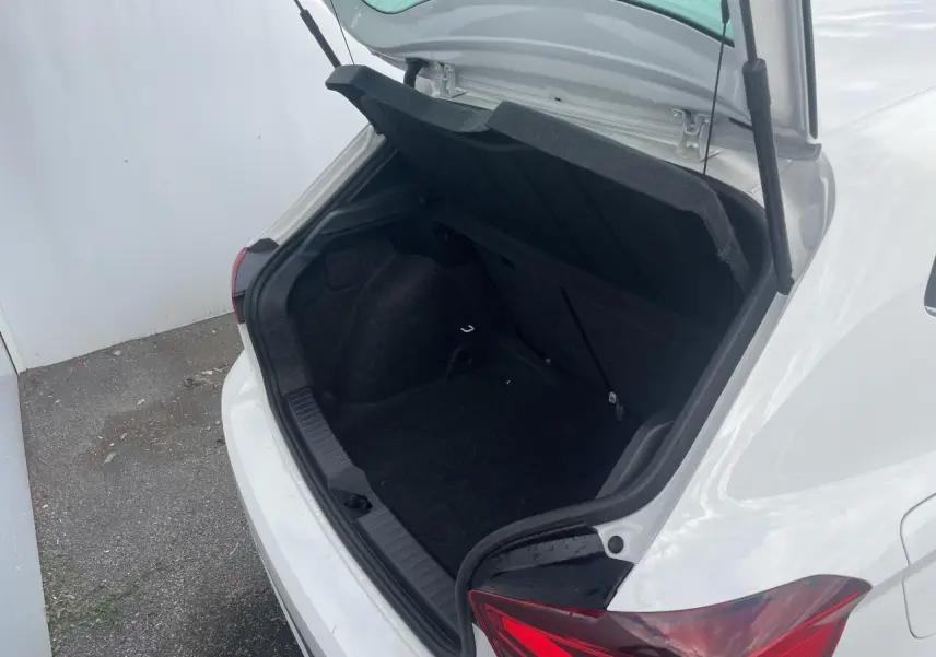 Coffre ouvert vu de l'arrière droit d'une SEAT IBIZA blanche avec feux arrière LED en triangle.