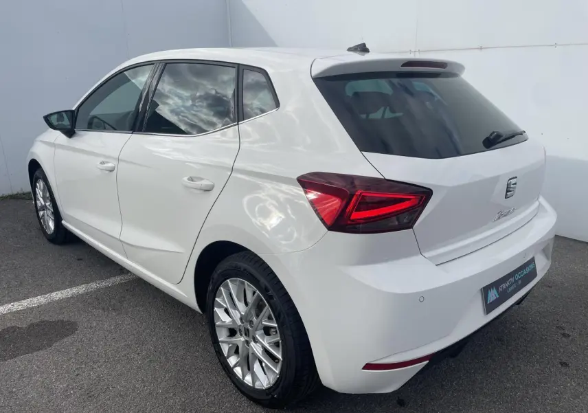 SEAT Ibiza blanche vue en 3/4 arrière droit, avec feux LED triangulaires et jantes alliage 16 pouces.