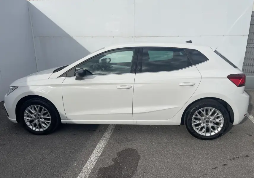 Profil côté gauche d'une SEAT Ibiza blanche 2025 avec jantes alliage et vitres surteintées arrière.