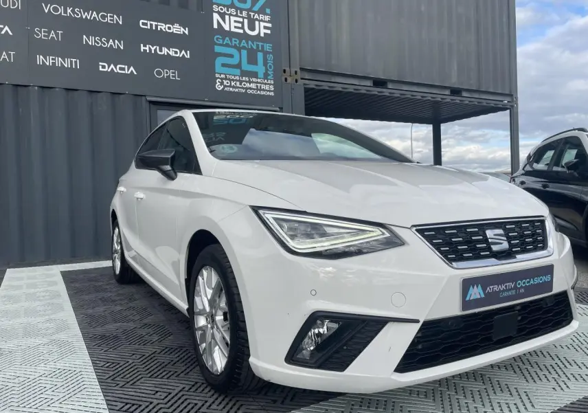 SEAT Ibiza blanche vue en 3/4 avant droit, avec phares LED triangulaires et jantes alliage 16 pouces.