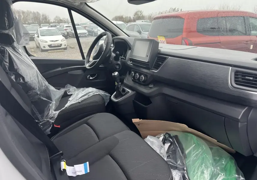 Vue latérale droite d’un utilitaire blanc Nissan Primastar 2025 avec porte coulissante ouverte montrant l’intérieur vide.