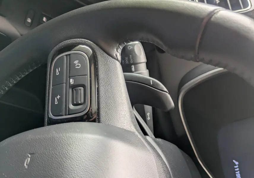 Vue rapprochée du volant noir de la Citroën C5 Aircross 2020, montrant les commandes au volant et le tableau de bord numérique.