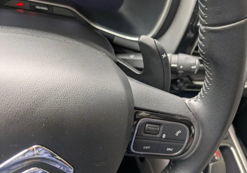 Gros plan sur le volant noir du Citroën C5 Aircross 2020, montrant les commandes audio et téléphone intégrées.