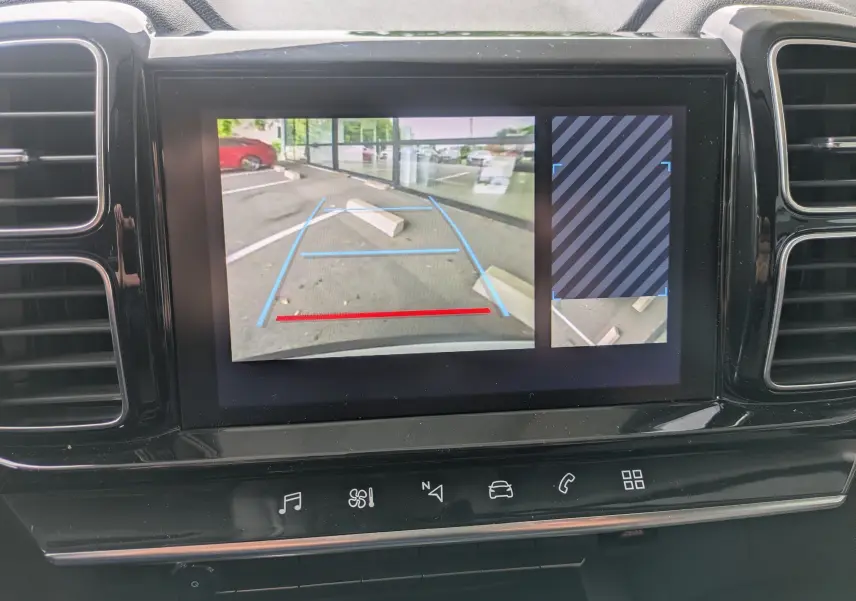 Écran central du Citroën C5 Aircross blanc montrant la caméra de recul avec lignes de guidage bleues et rouges.