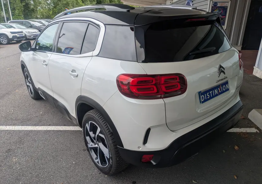 Vue 3/4 arrière droite d'un Citroën C5 Aircross blanc avec toit noir et feux arrière distinctifs en forme de double 8.