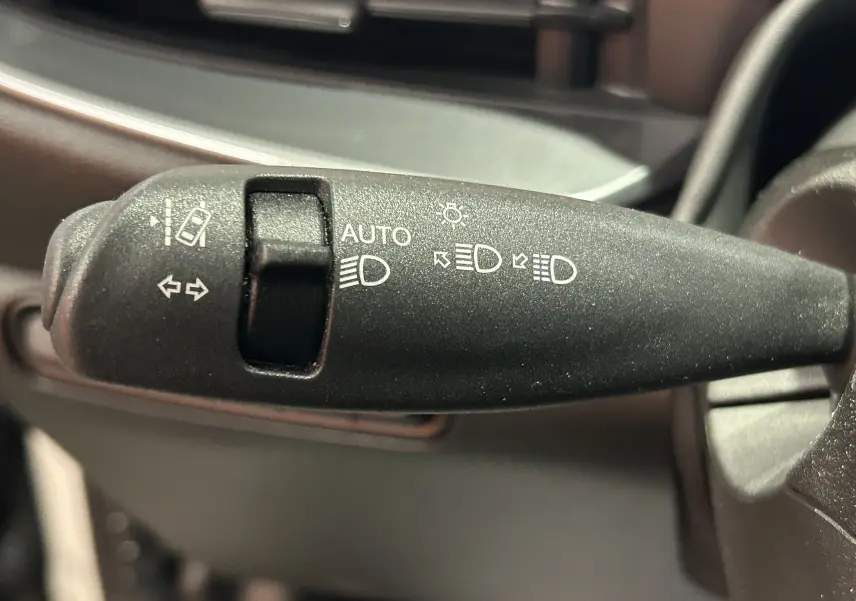 Gros plan sur la commande de feux et clignotants noire à l'intérieur de la Fiat 500 électrique 2023.