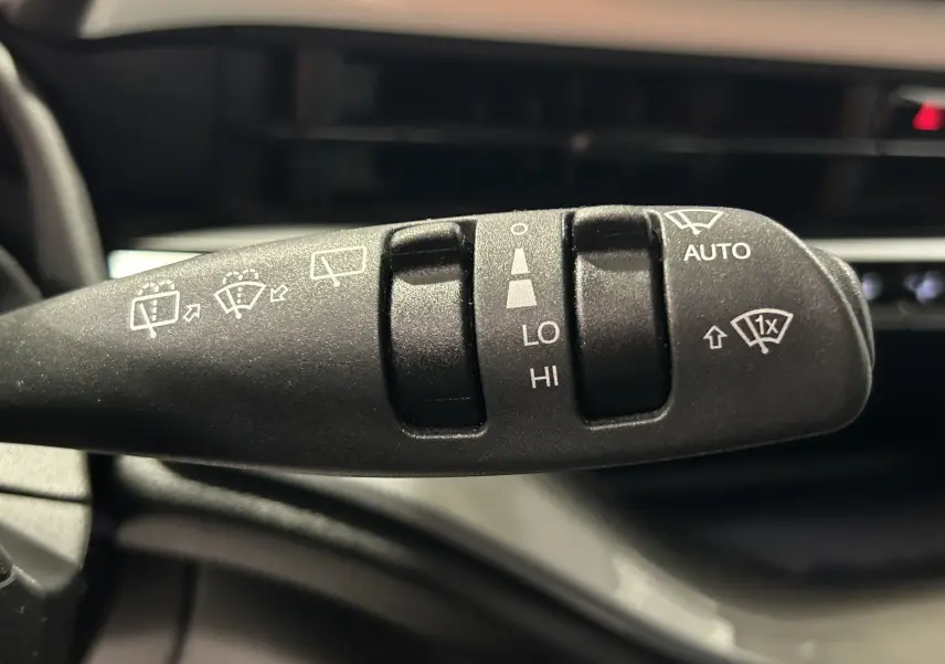 Gros plan sur la commande de l'essuie-glace intérieur d'une Fiat 500 électrique 2023, détails des fonctions visibles.