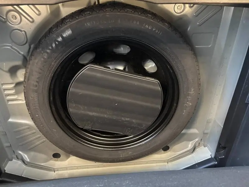 Gros plan sur la roue de secours noire logée dans le coffre de l'Opel Grandland 1.2 Turbo Ultimate 2022.