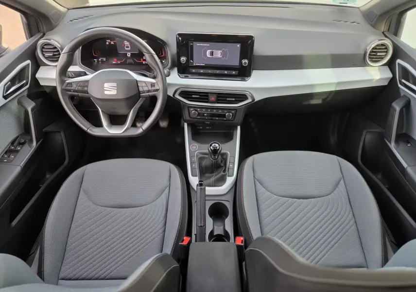 Intérieur de la SEAT Ibiza 2025 vu de face, tableau de bord moderne avec écran tactile et volant multifonction.