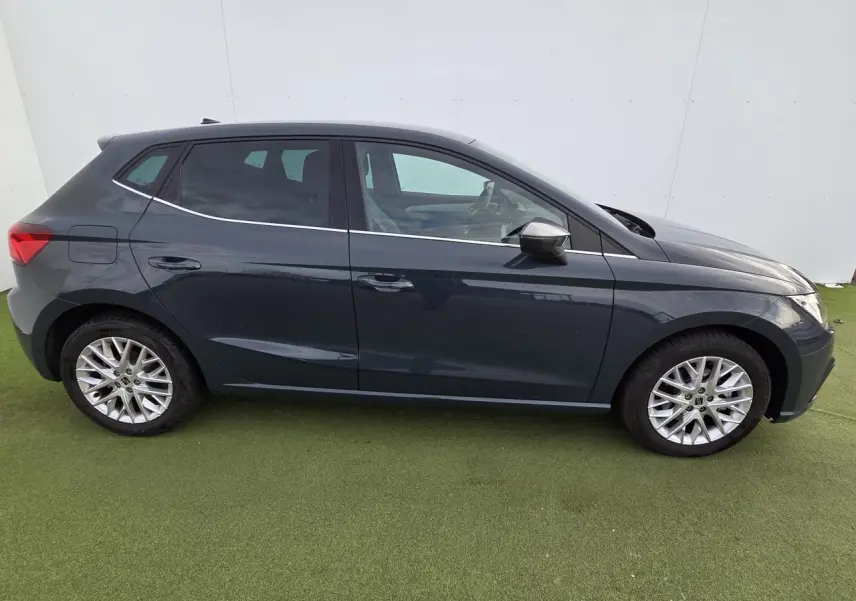 Profil côté gauche d'une SEAT IBIZA 2025 bleu fjord métal avec jantes alliage et vitres teintées arrière.