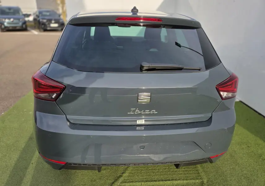 Vue arrière d'une SEAT Ibiza bleu Fjord métallisé avec feux LED triangulaires et lunette arrière teintée.