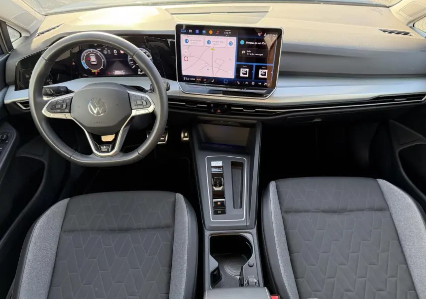 Vue intérieure avant de la Volkswagen Golf 2.0 TDI 2025 avec tableau de bord digital et écran tactile central.