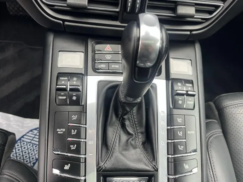 Gros plan sur le levier de vitesse PDK en aluminium et les commandes de climatisation du Porsche Macan noir de 2018.