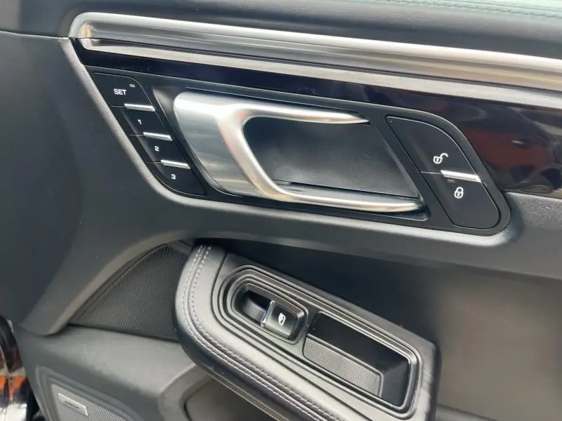 Poignée de porte intérieure côté gauche en aluminium et cuir noir du Porsche Macan 2.0 2018 avec boutons de verrouillage et réglages mémoire.