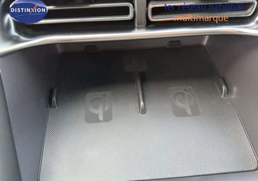 Gros plan sur le chargeur sans fil Qi intégré dans la console centrale du BYD SEAL U hybride rechargeable.