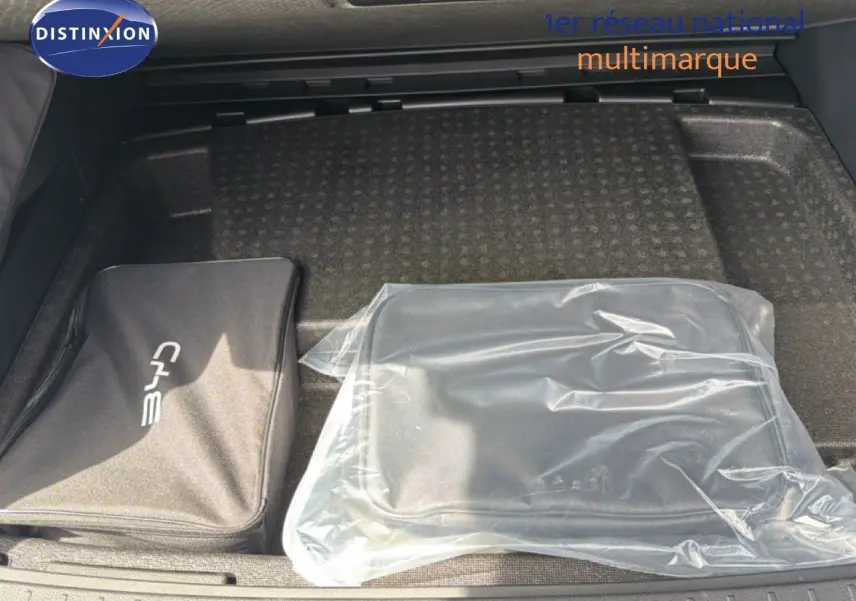 Coffre ouvert d’un BYD SEAL U blanc neige, vue plongeante sur deux sacs de rangement posés à plat.