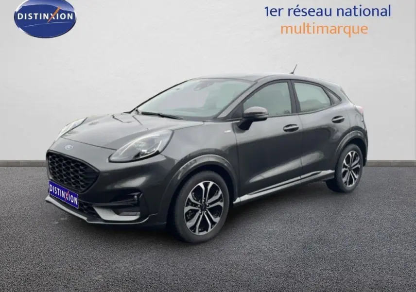 Ford Puma gris foncé en 3/4 avant droit, avec jantes alliage 17 pouces et calandre noire distinctive.