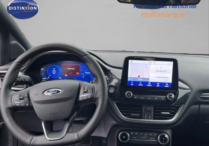 Vue intérieure frontale du tableau de bord du Ford Puma gris foncé 2024 avec écran tactile et volant multifonction.