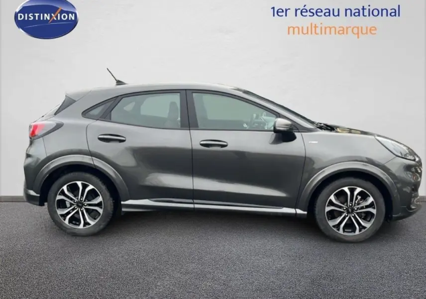 Vue de profil côté gauche d’un Ford Puma gris foncé avec jantes alliage 17 pouces sur fond neutre.