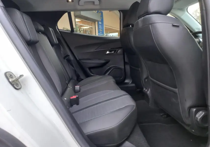 Vue intérieure côté gauche des sièges arrière en tissu noir et gris du Peugeot 2008 blanc, version Allure Pack 2021.