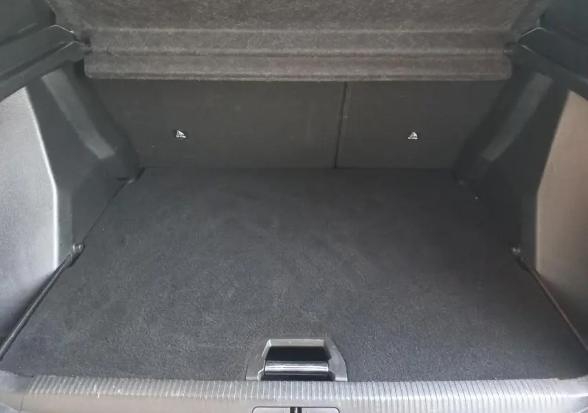 Coffre spacieux et propre du Peugeot 2008 blanc, vue intérieure depuis l'arrière avec tapis noir et seuil de chargement visible.