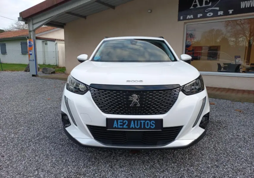 Peugeot 2008 blanc vue de face, mettant en valeur la calandre noire et les phares modernes.