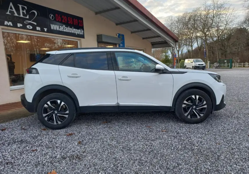 Peugeot 2008 blanc vue de profil côté gauche, avec jantes alliage et toit noir contrastant.
