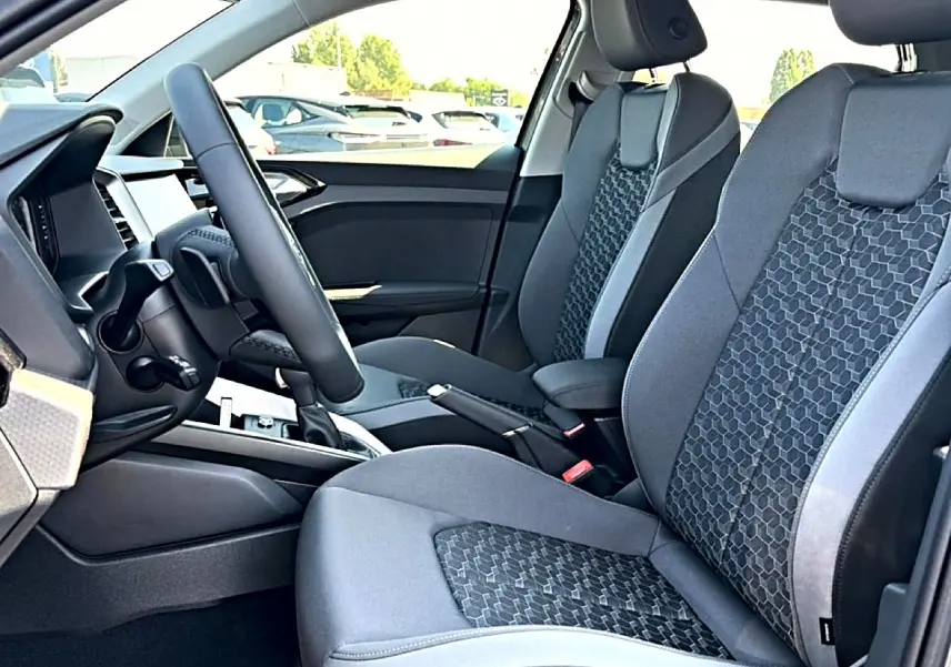 Vue intérieure côté conducteur de l’Audi A1 Sportback 30 TFSI 116 S line 2026 avec sièges sport gris à motif hexagonal.