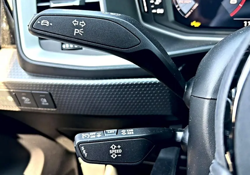 Gros plan sur les commandes au volant noir d’une Audi A1 Sportback 30 TFSI 2026 avec tableau de bord numérique.