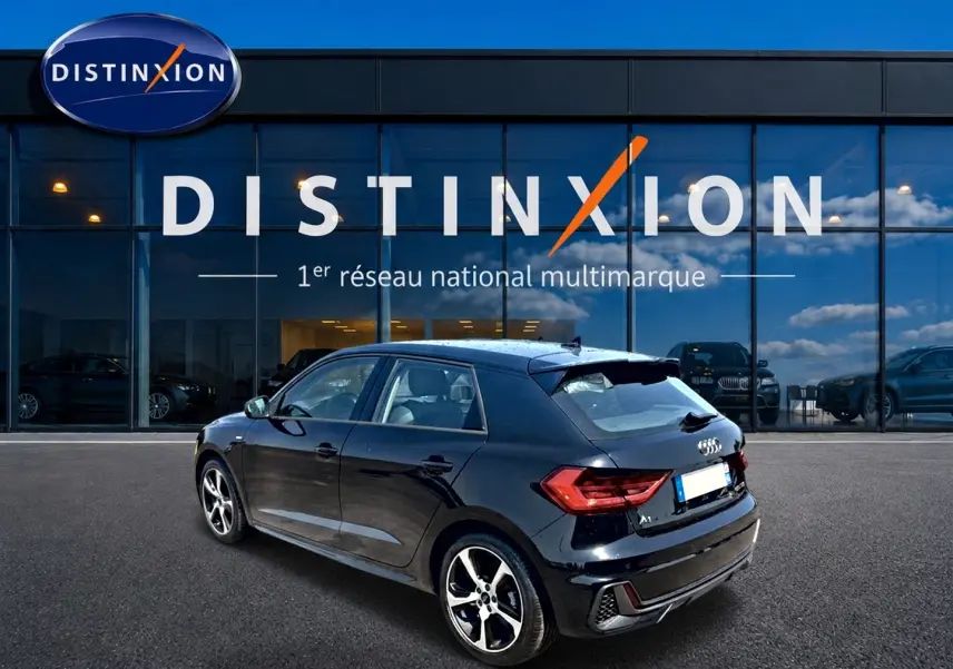 Audi A1 Sportback noir vue 3/4 arrière droit, avec jantes alliage et becquet arrière distinctif.