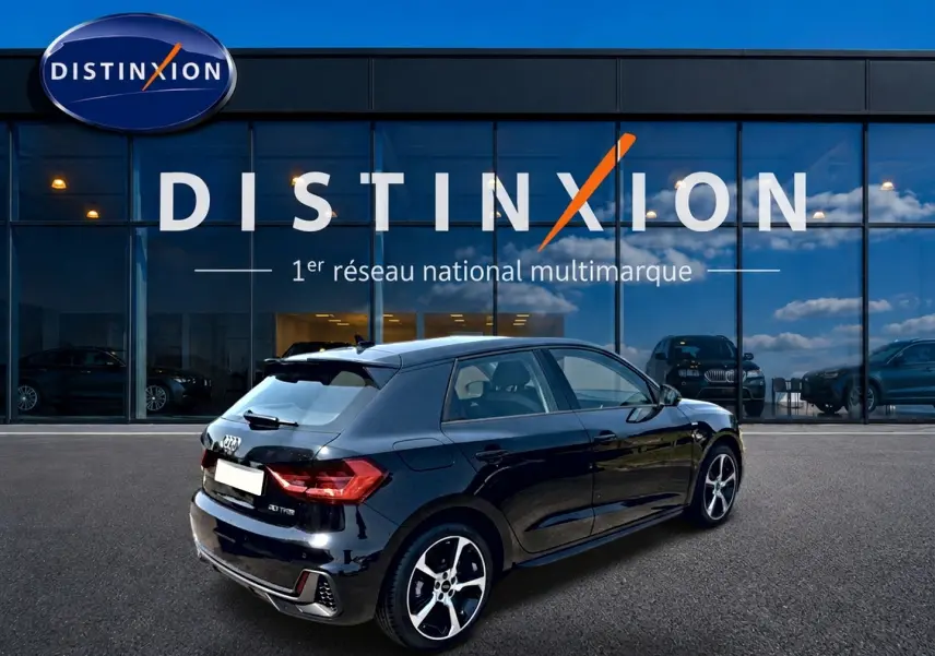 Audi A1 Sportback noir vue 3/4 arrière droit avec jantes alliage et becquet arrière, devant showroom Distinxion.