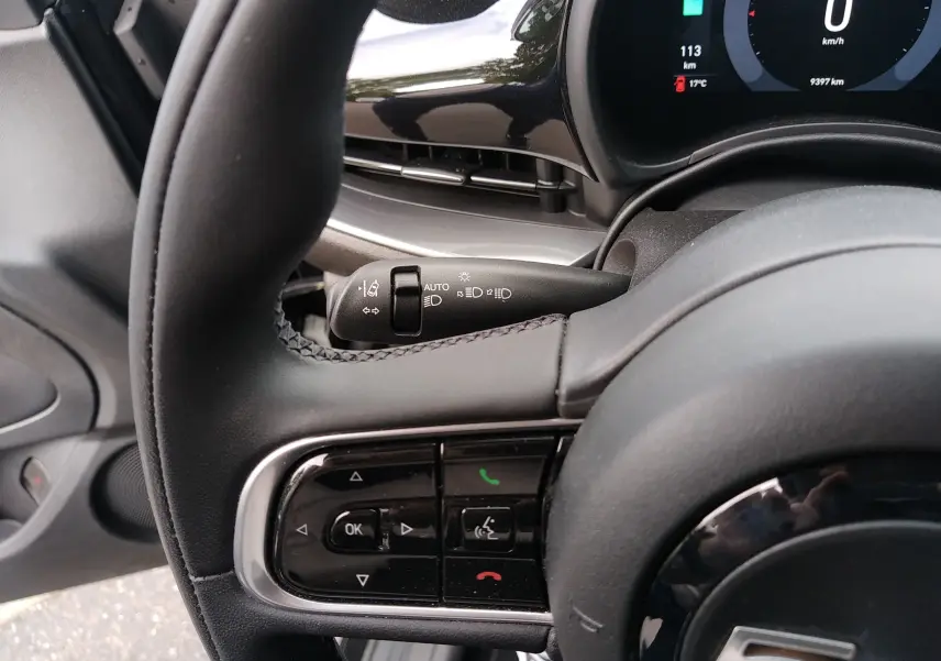 Gros plan sur le volant noir et le combiné d'instruments digital de la Fiat 500 électrique 2024, côté gauche.