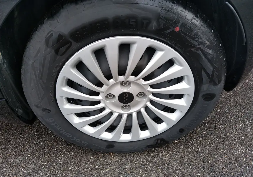 Gros plan sur la jante argentée de la roue avant droite d'une FIAT 500 électrique noire 2024.