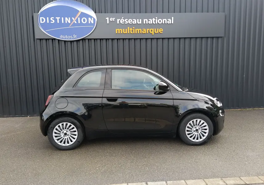 Profil droit d'une Fiat 500 électrique noire 2024, compacte avec jantes argentées et toit panoramique.
