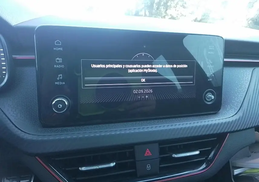 Vue rapprochée de l’écran tactile central du tableau de bord avec insert effet carbone et liseré rouge du Skoda Scala noir.