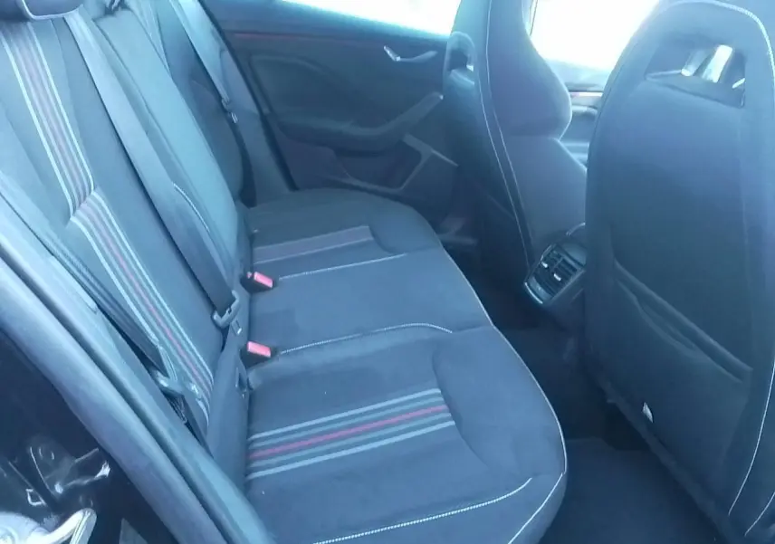 Vue intérieure côté gauche des sièges arrière noirs avec bandes rouges et grises sur Skoda Scala Monte-Carlo 2025.