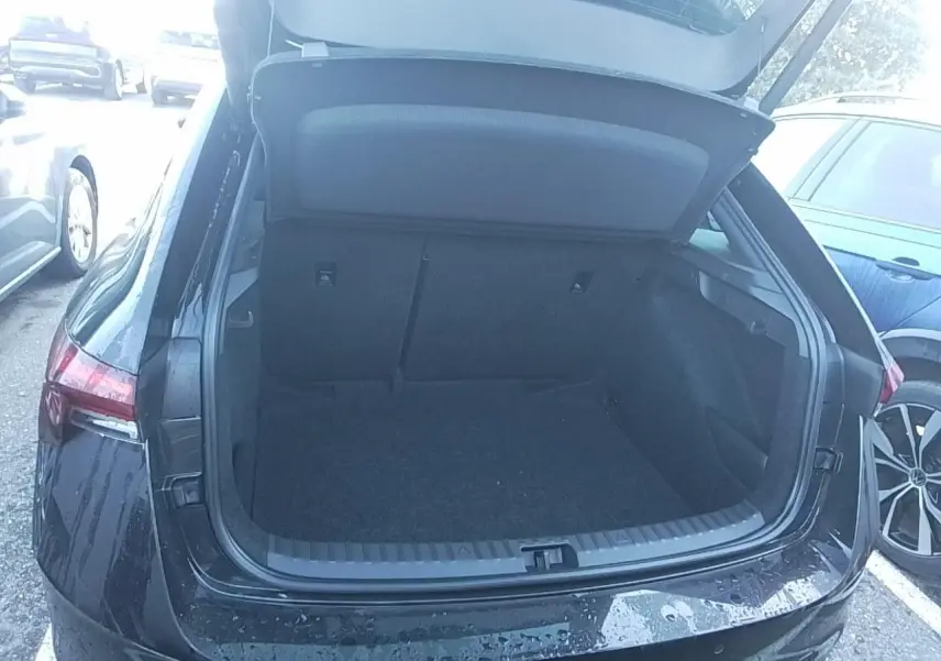 Vue arrière du coffre ouvert d'une Skoda Scala TSI 116 DSG7 Monte-Carlo en noir Magic, avec hayon électrique.