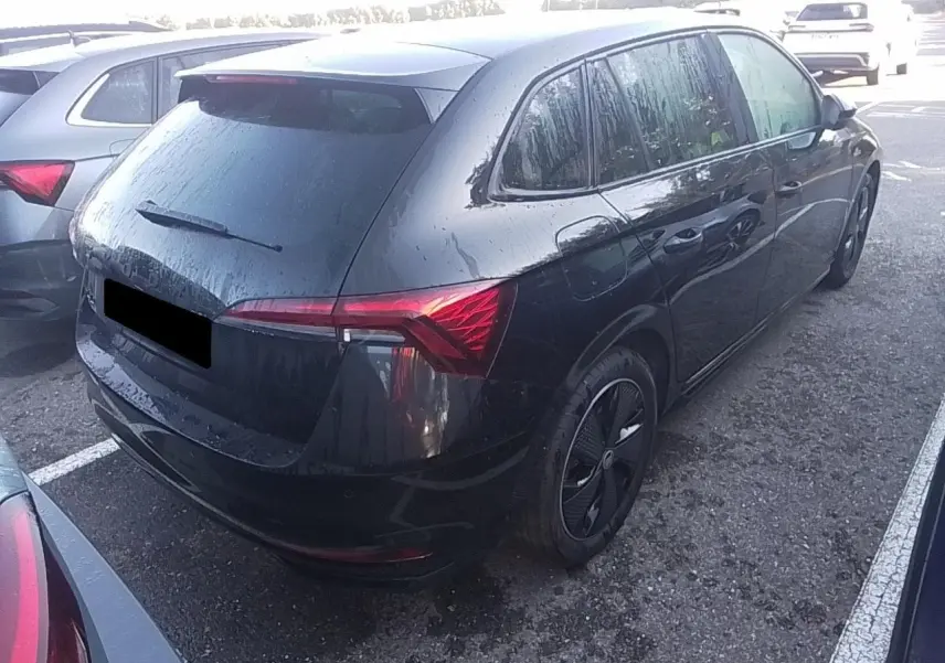 Vue 3/4 arrière droite d'une Skoda Scala TSI 116 DSG7 Monte-Carlo noire avec hayon électrique et jantes noires.