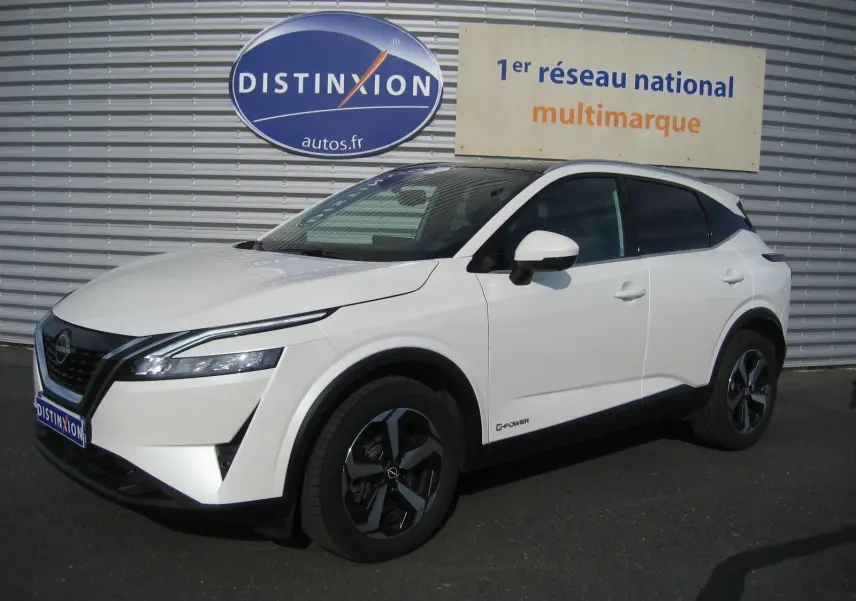 Nissan Qashqai blanc en 3/4 avant droit, avec jantes bi-ton noires et logo e-power sur la portière.