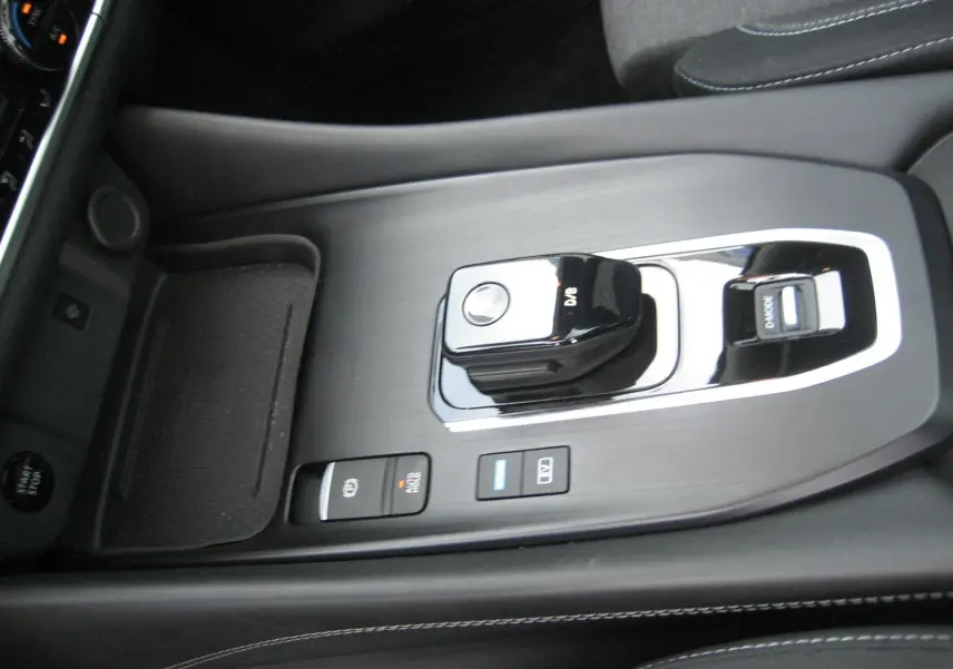 Vue rapprochée de la console centrale noire du Nissan Qashqai 2024 avec levier de vitesse automatique et boutons de commande.