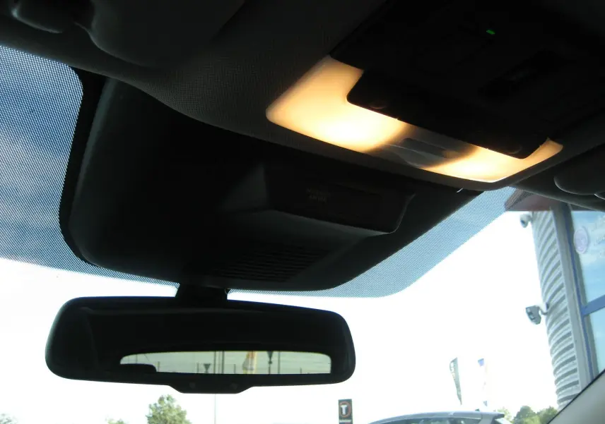 Plafonnier allumé et rétroviseur intérieur d'un Nissan Qashqai blanc 2024, vue depuis l'habitacle avant.