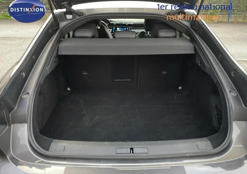 Coffre ouvert vu de l'arrière d'une Peugeot 508 gris platinium métal, montrant l'espace de chargement vide.