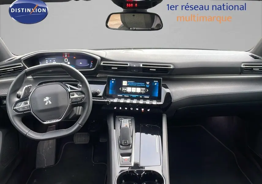Vue intérieure avant du tableau de bord et volant du Peugeot 508 gris platinium, avec écran tactile central et commandes modernes.