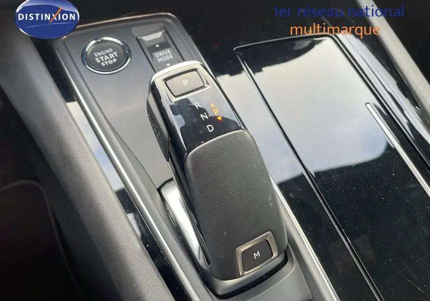 Vue rapprochée du levier de vitesse automatique de la Peugeot 508 gris platinium métal, avec bouton start/stop et drive mode.