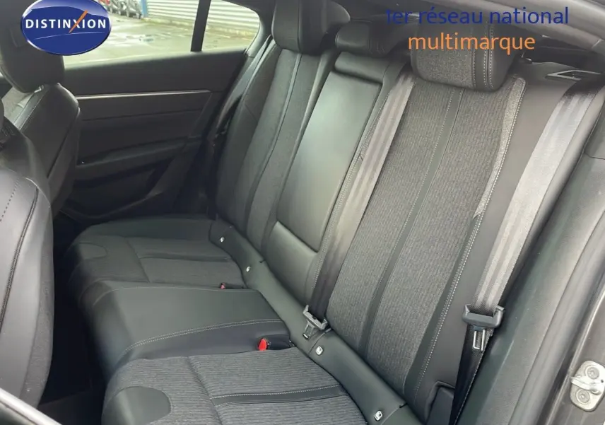 Vue intérieure montrant la banquette arrière en cuir et tissu gris d’une Peugeot 508 2023, porte arrière ouverte.