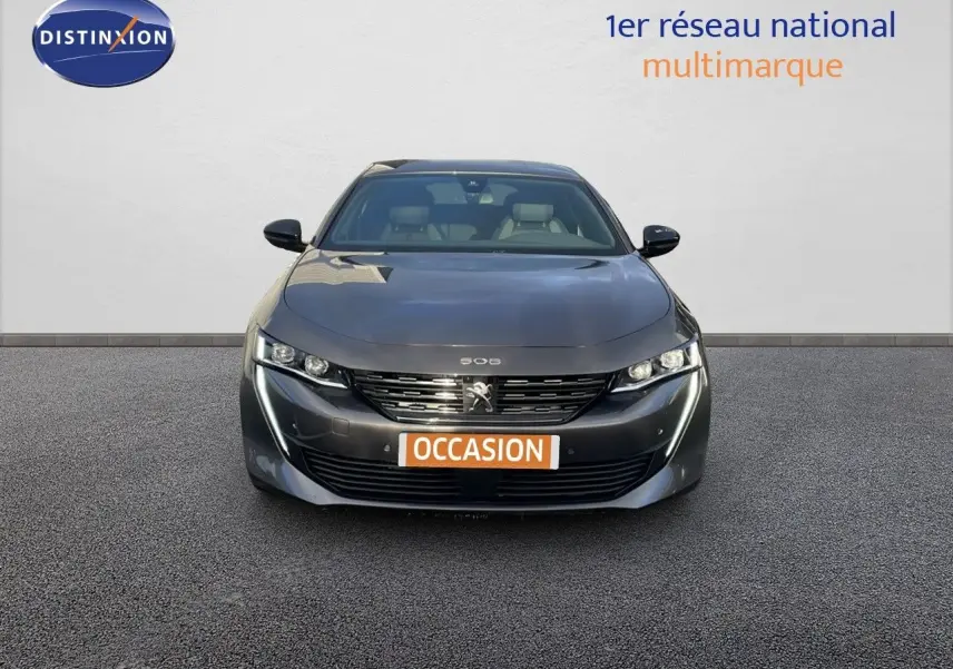 Vue frontale d'une Peugeot 508 gris platinium métal 2023 avec calandre et feux LED distinctifs, plaque "OCCASION" visible.