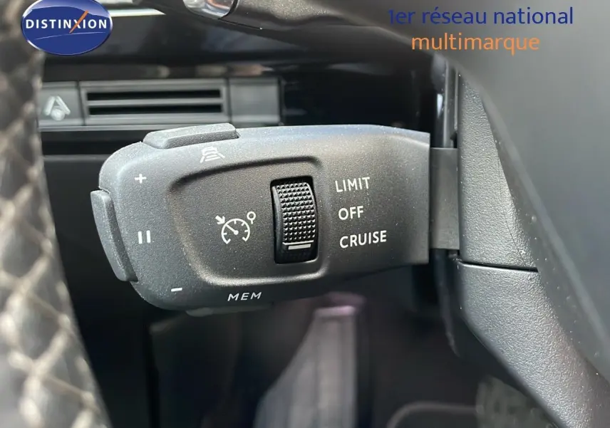 Gros plan sur la commande de régulateur de vitesse au volant d'une Peugeot 508 gris platinium, intérieur noir.