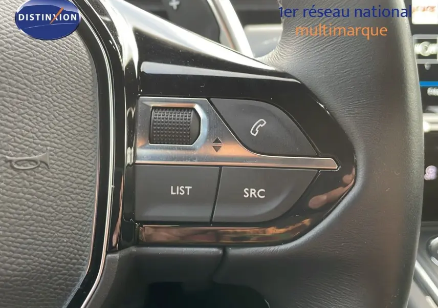 Gros plan sur les commandes gauche du volant en cuir noir du Peugeot 508 gris platinium, avec boutons LIST et SRC visibles.