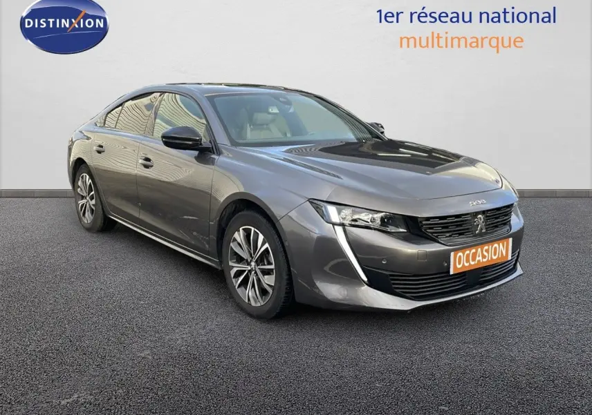 Peugeot 508 gris platinium métal vue 3/4 avant avec phares LED et calandre distinctive, sur fond neutre.