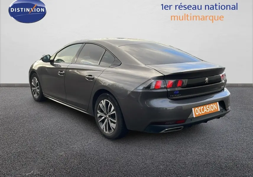 Vue 3/4 arrière droite d'une Peugeot 508 gris platinium métal avec feux arrière LED et double sortie d'échappement.